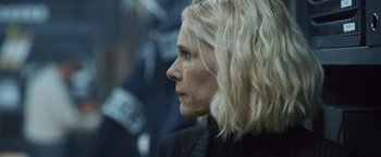 Movie still from “Lost Bullet 2: Back for More” (2022), directed by Guillaume Pierret – A person with blonde hair; Close Up shot, Over the shoulder angle