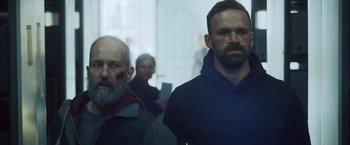 Movie still from “Lost Bullet 2: Back for More” (2022), directed by Guillaume Pierret – Two men with bandages on their faces and one man with a bandage on his face; Medium shot, Low angle
