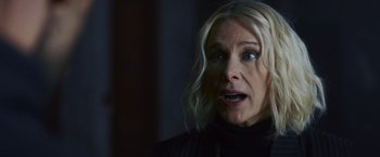 Movie still from “Lost Bullet 2: Back for More” (2022), directed by Guillaume Pierret – A woman with blonde long hair and a black jacket; Close Up shot, Over the shoulder angle