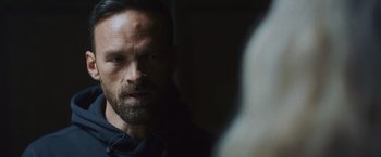 Movie still from “Lost Bullet 2: Back for More” (2022), directed by Guillaume Pierret – A person wearing a black shirt; Close Up shot, Over the shoulder angle