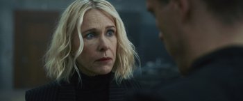 Movie still from “Lost Bullet 2: Back for More” (2022), directed by Guillaume Pierret – A woman is looking at a man in a black suit; Close Up shot, Over the shoulder angle