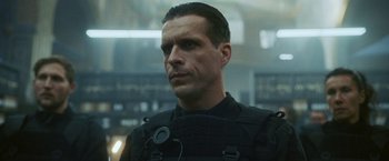 Movie still from “Lost Bullet 2: Back for More” (2022), directed by Guillaume Pierret – A person wearing a uniform; Close Up shot, Low angle