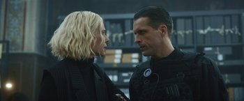 Movie still from “Lost Bullet 2: Back for More” (2022), directed by Guillaume Pierret – A man and a woman are standing next to each other; Close Up shot, Over the shoulder angle