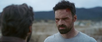 Movie still from “Lost Bullet 2: Back for More” (2022), directed by Guillaume Pierret – A person with a face covered in blood; Close Up shot, Over the shoulder angle