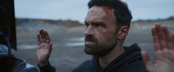 Movie still from “Lost Bullet 2: Back for More” (2022), directed by Guillaume Pierret – A person with a head injury; Close Up shot, Over the shoulder angle