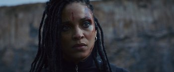 Movie still from “Lost Bullet 2: Back for More” (2022), directed by Guillaume Pierret – A person with dreadlocks; Close Up shot, Low angle