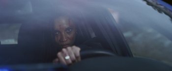 Movie still from “Lost Bullet 2: Back for More” (2022), directed by Guillaume Pierret – A woman in a car looking at the camera; Close Up shot, Low angle