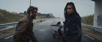 Movie still from “Lost Bullet 2: Back for More” (2022), directed by Guillaume Pierret – A man and a woman on the side of a road; Medium shot, Over the shoulder angle