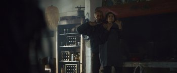 Movie still from “Lost Bullet 2: Back for More” (2022), directed by Guillaume Pierret – A man and a woman are standing in a living room; Medium shot, Low angle