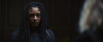 A woman with dreadlocks is looking at the camera
