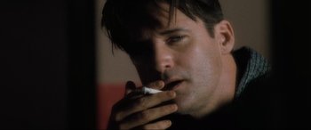 Movie still from “Lost Highway” (1997), directed by David Lynch – A person holding a piece of food; Close Up shot, Low angle