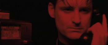 Movie still from “Lost Highway” (1997), directed by David Lynch – A man's face in a dark room; Close Up shot, Low angle