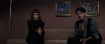 Movie still from “Lost Highway” (1997), directed by David Lynch – A woman standing in front of a painting on the wall; Medium shot, Over the shoulder angle