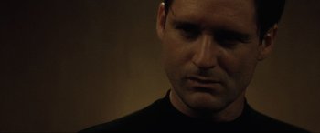 Movie still from “Lost Highway” (1997), directed by David Lynch – A person wearing a black shirt; Close Up shot, Low angle
