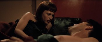 Movie still from “Lost Highway” (1997), directed by David Lynch – A woman sitting on top of a black couch; Close Up shot, High angle