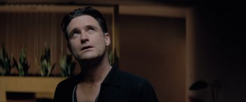 Movie still from “Lost Highway” (1997), directed by David Lynch – A person wearing a black shirt looking up; Close Up shot, Low angle