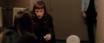 Movie still from “Lost Highway” (1997), directed by David Lynch – A woman holding a wii remote in her hand; Medium shot, Over the shoulder angle