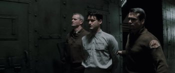 Movie still from “Lost Highway” (1997), directed by David Lynch – Two men standing next to each other in front of a wall; Medium shot, Low angle