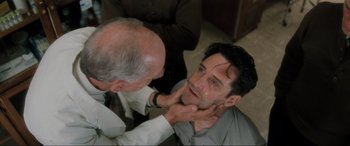 Movie still from “Lost Highway” (1997), directed by David Lynch – A man is getting his face waxed by another man; Close Up shot, Over the shoulder angle