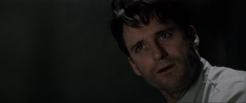 Movie still from “Lost Highway” (1997), directed by David Lynch – A person's face in a dark room; Close Up shot, Low angle