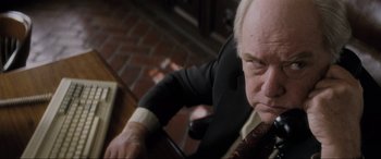 Movie still from “Lost Highway” (1997), directed by David Lynch – An older man wearing a suit and tie looking down; Close Up shot, Low angle
