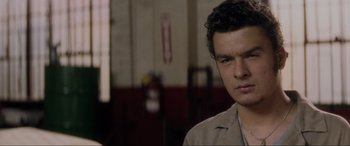 Movie still from “Lost Highway” (1997), directed by David Lynch – A young man in a tan shirt is looking at the camera; Close Up shot, Over the shoulder angle