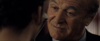 Movie still from “Lost Highway” (1997), directed by David Lynch – An older man is looking at something on his phone; Close Up shot, Over the shoulder angle