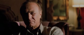 Movie still from “Lost Highway” (1997), directed by David Lynch – An older man sitting in a chair with his eyes wide open; Close Up shot, Low angle