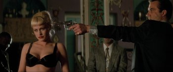 Movie still from “Lost Highway” (1997), directed by David Lynch – A man in a suit is holding a gun in his hand; Medium shot, Over the shoulder angle