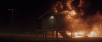Movie still from “Lost Highway” (1997), directed by David Lynch – A house on fire at night with the lights on; Extreme Wide shot, Low angle