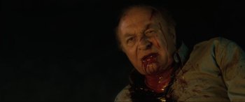 Movie still from “Lost Highway” (1997), directed by David Lynch – An old man with blood on his face and mouth; Close Up shot, High angle