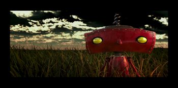 Movie still from “Lou” (2022), directed by Anna Foerster – A red robot in the middle of a grassy field; Extreme Close Up shot, Overhead angle