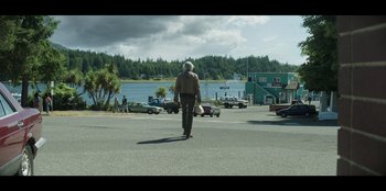 Movie still from “Lou” (2022), directed by Anna Foerster – An older man is walking across the street; Extreme Wide shot, Low angle
