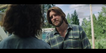 Movie still from “Lou” (2022), directed by Anna Foerster – A man with long hair and a beard talking to another man; Close Up shot, Over the shoulder angle