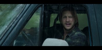 Movie still from “Lou” (2022), directed by Anna Foerster – A man sitting in the driver's seat of a truck; Close Up shot, Over the shoulder angle