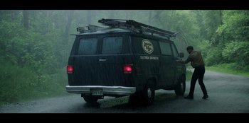 Movie still from “Lou” (2022), directed by Anna Foerster – An electrical contracting van driving down a road; Wide shot, Low angle