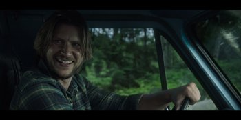 Movie still from “Lou” (2022), directed by Anna Foerster – A man sitting in the driver's seat of a car; Close Up shot, Over the shoulder angle