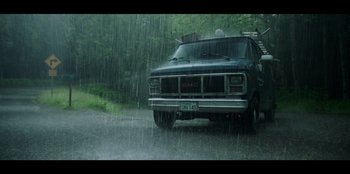 Movie still from “Lou” (2022), directed by Anna Foerster – A truck driving down a road in the rain; Extreme Wide shot, Low angle