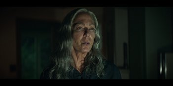 Movie still from “Lou” (2022), directed by Anna Foerster – An older woman with long gray hair looking at the camera; Close Up shot, Low angle