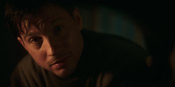 Movie still from “Lou” (2022), directed by Anna Foerster – A man's face in the dark; Close Up shot, Over the shoulder angle