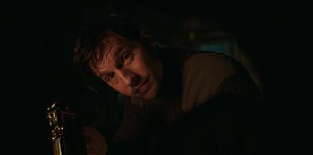 Movie still from “Lou” (2022), directed by Anna Foerster – A person in a dark room; Close Up shot, Low angle