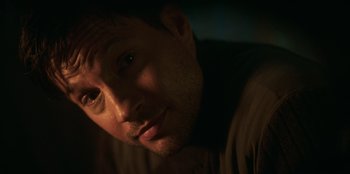 Movie still from “Lou” (2022), directed by Anna Foerster – A man's face in the dark; Close Up shot, Over the shoulder angle