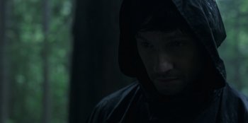 Movie still from “Lou” (2022), directed by Anna Foerster – A man in a hooded jacket looking down at the ground; Close Up shot, Low angle