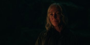 Movie still from “Lou” (2022), directed by Anna Foerster – An older woman with long white curly hair; Close Up shot, Over the shoulder angle