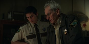 Movie still from “Lou” (2022), directed by Anna Foerster – A man in a brown jacket and a man in a brown jacket; Medium shot, Over the shoulder angle