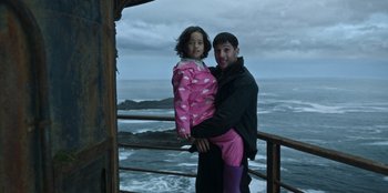 Movie still from “Lou” (2022), directed by Anna Foerster – A man holding a little girl on top of a railing; Medium shot, High angle