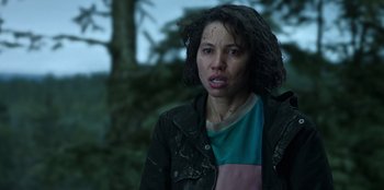 Movie still from “Lou” (2022), directed by Anna Foerster – A woman in a black jacket is standing in front of a tree; Close Up shot, Over the shoulder angle