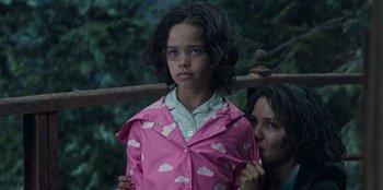 Movie still from “Lou” (2022), directed by Anna Foerster – A young girl wearing a pink raincoat with clouds on it; Close Up shot, Over the shoulder angle