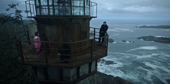 Movie still from “Lou” (2022), directed by Anna Foerster – A man standing on top of a metal tower; Wide shot, Low angle