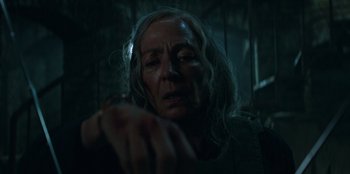 Movie still from “Lou” (2022), directed by Anna Foerster – An older woman with long hair looking at the camera; Close Up shot, Low angle